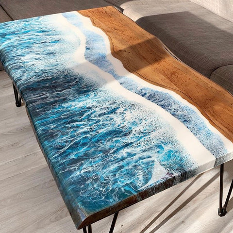 Epoxy Table with a river design in blue and white on a wooden surface, placed in a room.