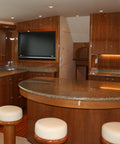 Luxury interior of a yacht with wooden paneling, marble countertop, and television.