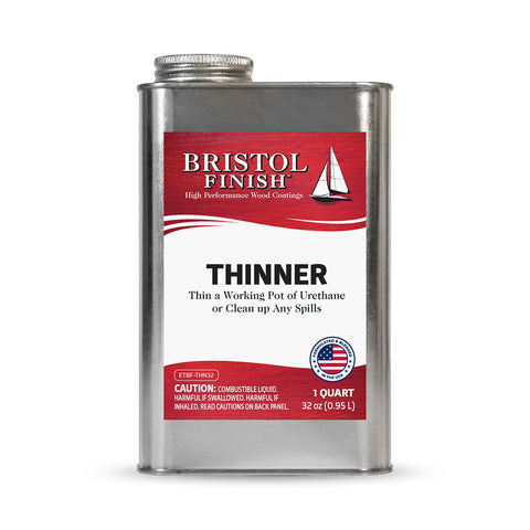 Can of Bristol Finish thinner with sailboat illustration on a wooden surface