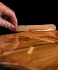 Spreading Crystal Sheen epoxy  onto a wooden surface.