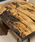Close-up of a wooden table with a rustic, charred finish.