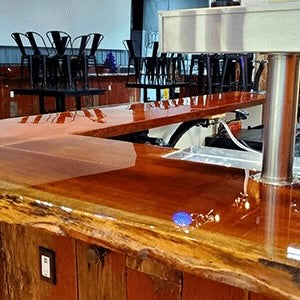 Wooden bar counter with a polished finish in a bar setting.