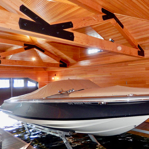 Boat inside a wooden garage with a covered entrance