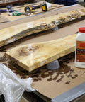 Wooden planks with a bottle of penetrating epoxy on a workbench.